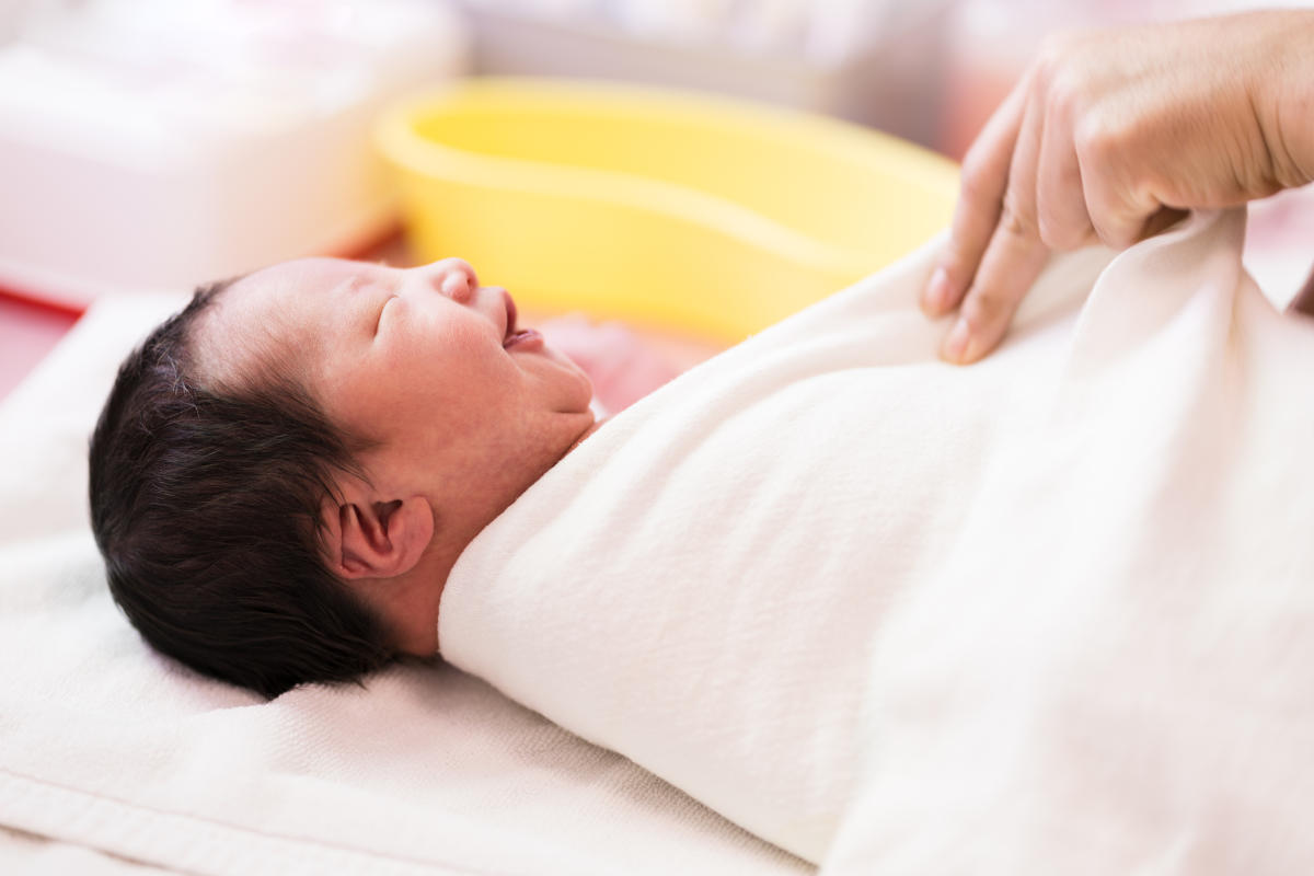 Bild: Neugeborenes wird in Decke gewickelt